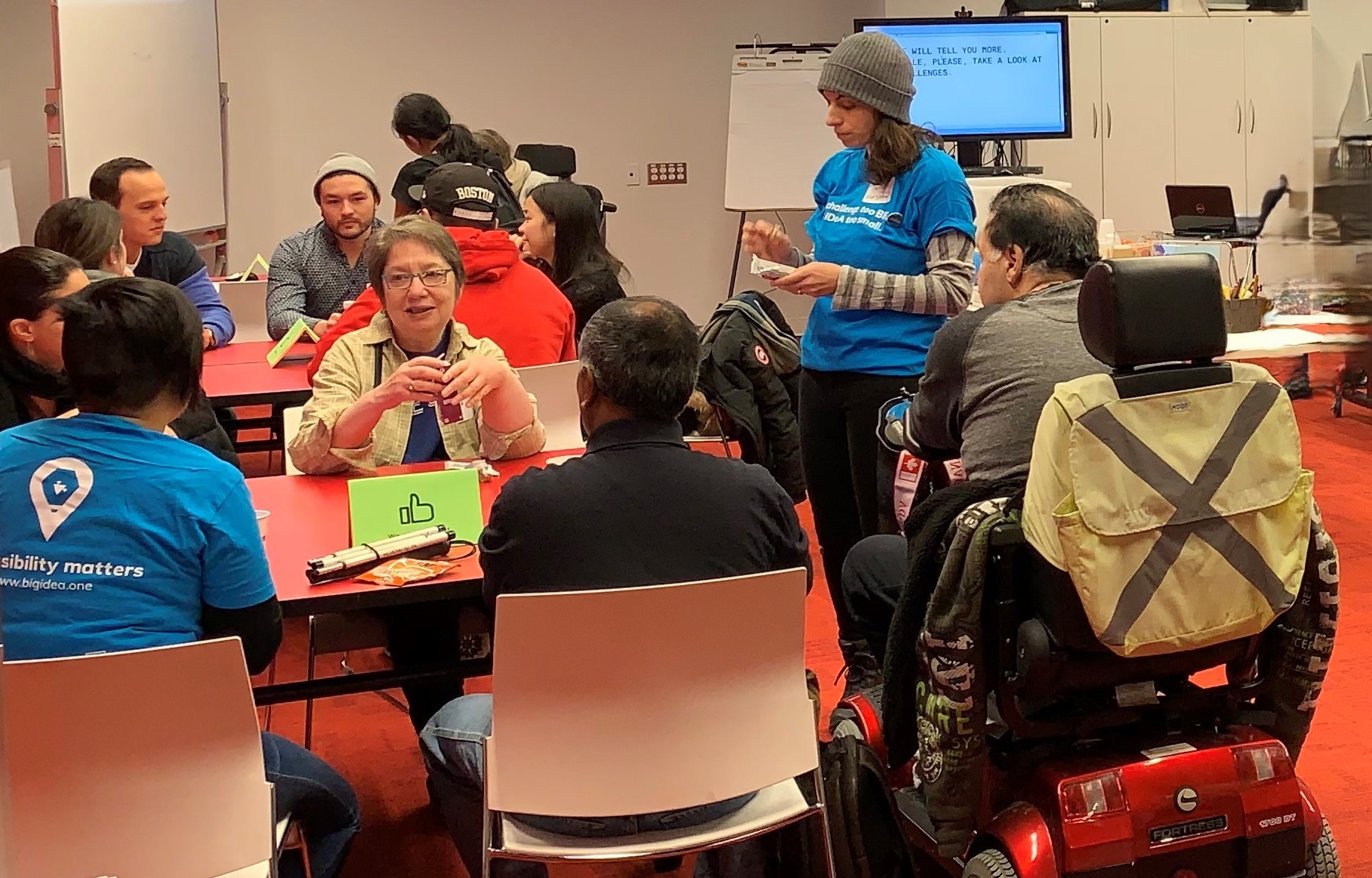 A group of diverse people work together. One uses a scooter.